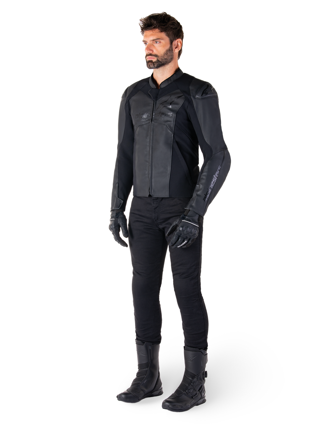 Alpinestars Faster V3 Leren Jas, Black Black, gedragen met een zwarte broek, handschoenen en laarzen, voorzien van een technische lederen constructie met HRSF-stretchpanelen, geïntegreerde DFS GP Lite-schouderbeschermers en een strak, sportief silhouet