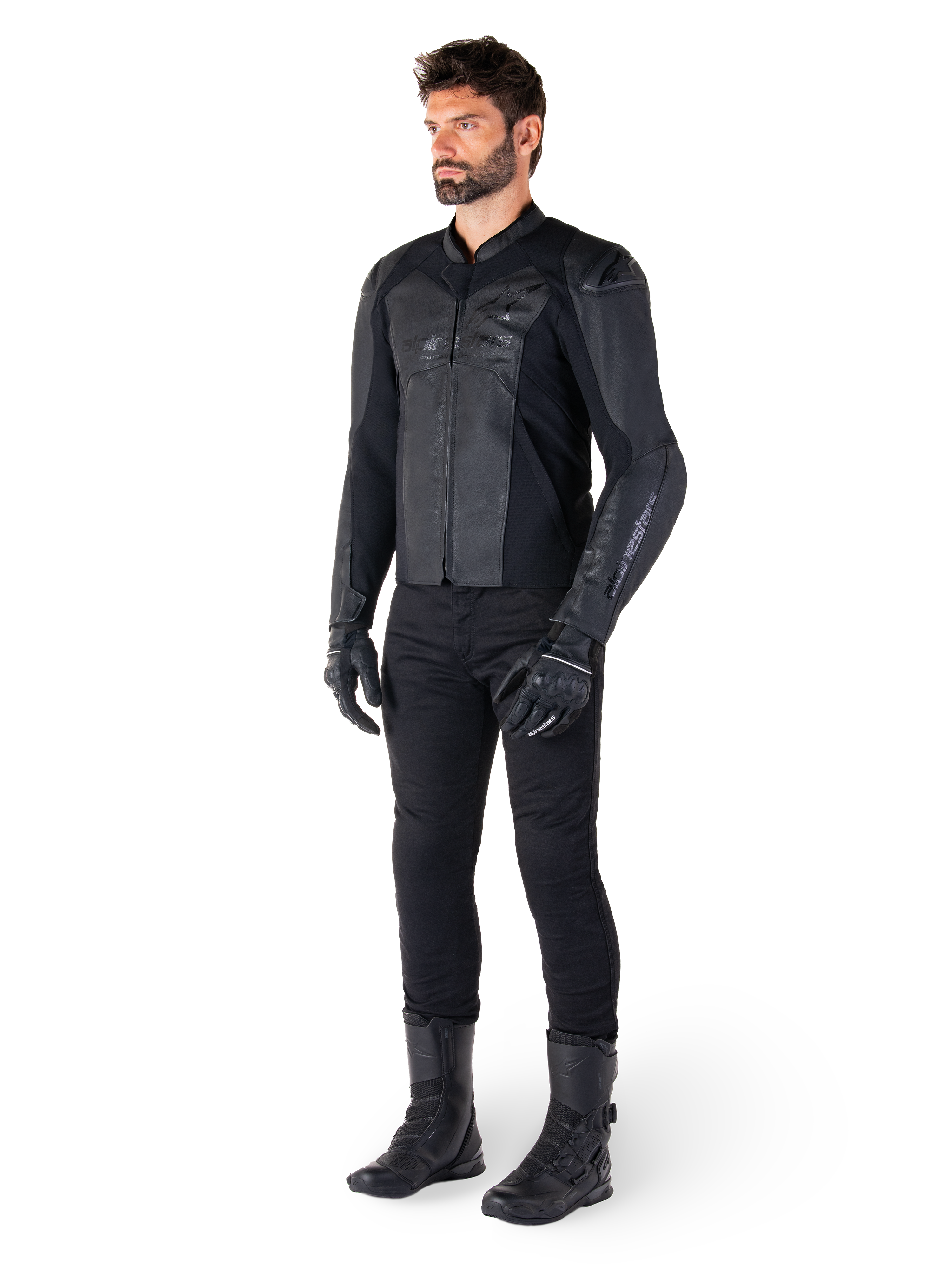 Alpinestars Faster V3 Leren Jas, Black Black, gedragen met een zwarte broek, handschoenen en laarzen, voorzien van een technische lederen constructie met HRSF-stretchpanelen, geïntegreerde DFS GP Lite-schouderbeschermers en een strak, sportief silhouet