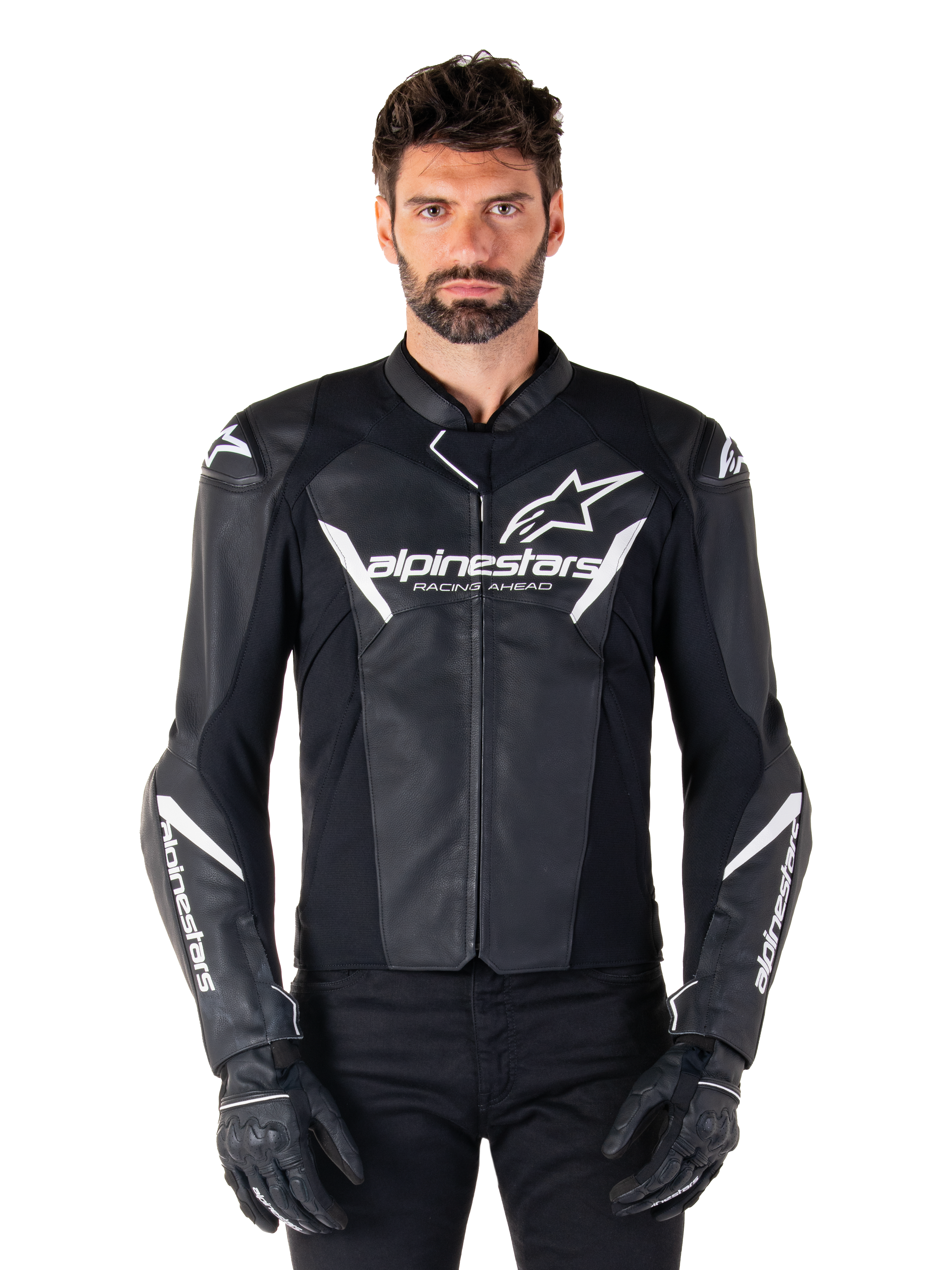 Alpinestars Faster V3 leren jas, zwart-wit motorracejack, voorzien van opvallende witte logo's en 'Racing Ahead' tekst op de borst, strak leren ontwerp met hoekige accenten op de mouwen, gedragen met zwarte racehandschoenen