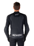 Alpinestars Faster V3 leren jas, sportieve motorjas, zwart met witte branding, achteraanzicht gedragen door model, voorzien van het Alpinestars-logo op de bovenrug en 'RACING AHEAD'-tekst op de onderrug, premium leren constructie met ergonomische stretchpanelen