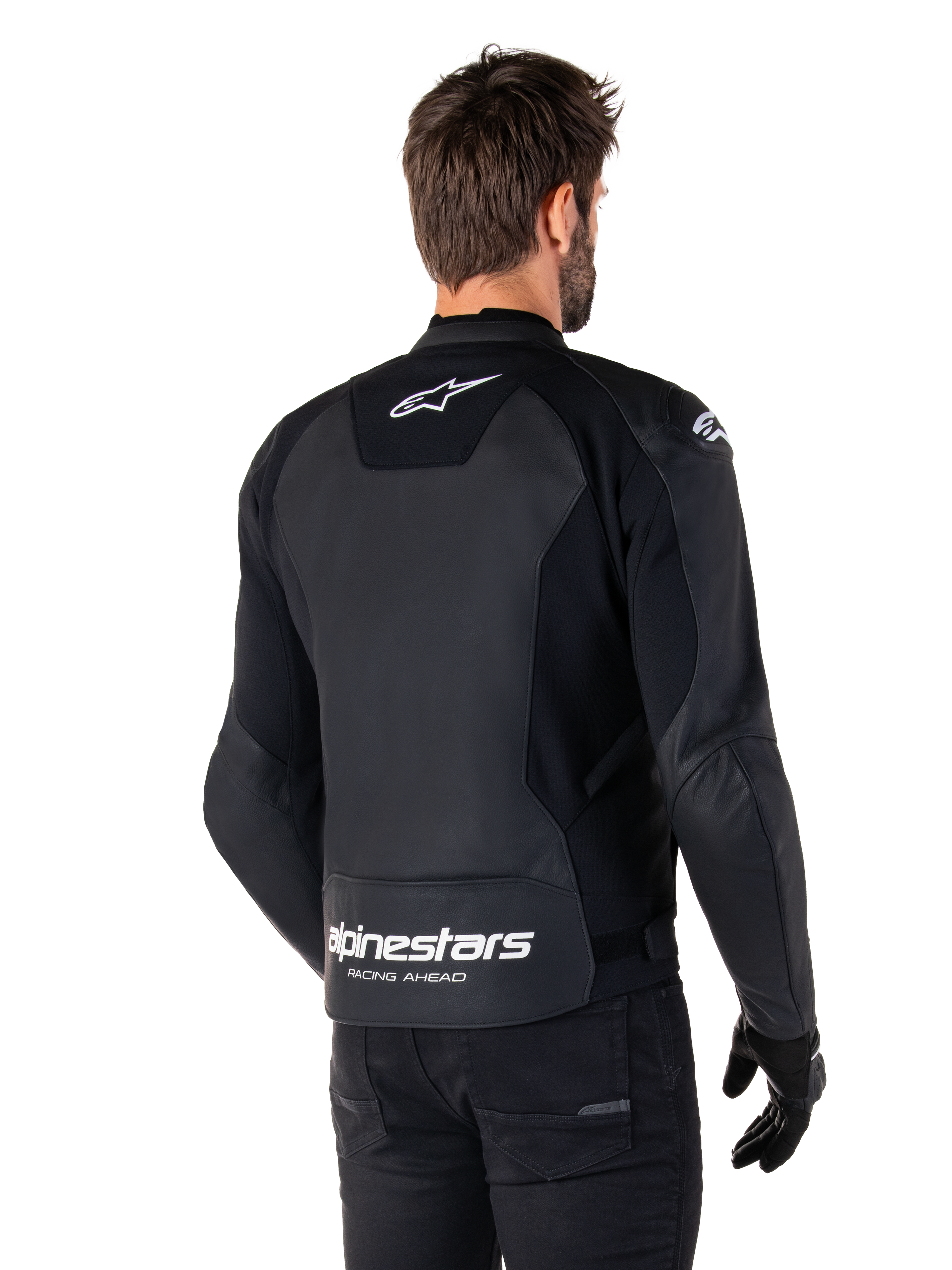 Alpinestars Faster V3 Leren Jas, zwart en wit, achteraanzicht op een rijder, met wit sterlogo op de bovenrug en groot Alpinestars-logo met "Racing Ahead" op de onderzijde van de rug, verlengde achterzijde voor extra bedekking tijdens het rijden, hoogwaardige sportleren constructie
