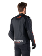 Alpinestars Faster V3 Airflow Leren Jas, sportief motorjack, zwart met rood fluo, achteraanzicht, voorzien van geperforeerde leren panelen, oranjerood Alpinestars-logo op de bovenrug en witte branding op de onderrug, gedragen met zwarte broek en handschoenen, strakke, race-geïnspireerde stijl