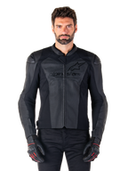 Man draagt Alpinestars Faster V3 Airflow leren motorjas, zwarte motorracejas met geperforeerde leren panelen, voorzien van Alpinestars-logo op de borst, gecombineerd met zwarte motorhandschoenen, studio-opname van voren.