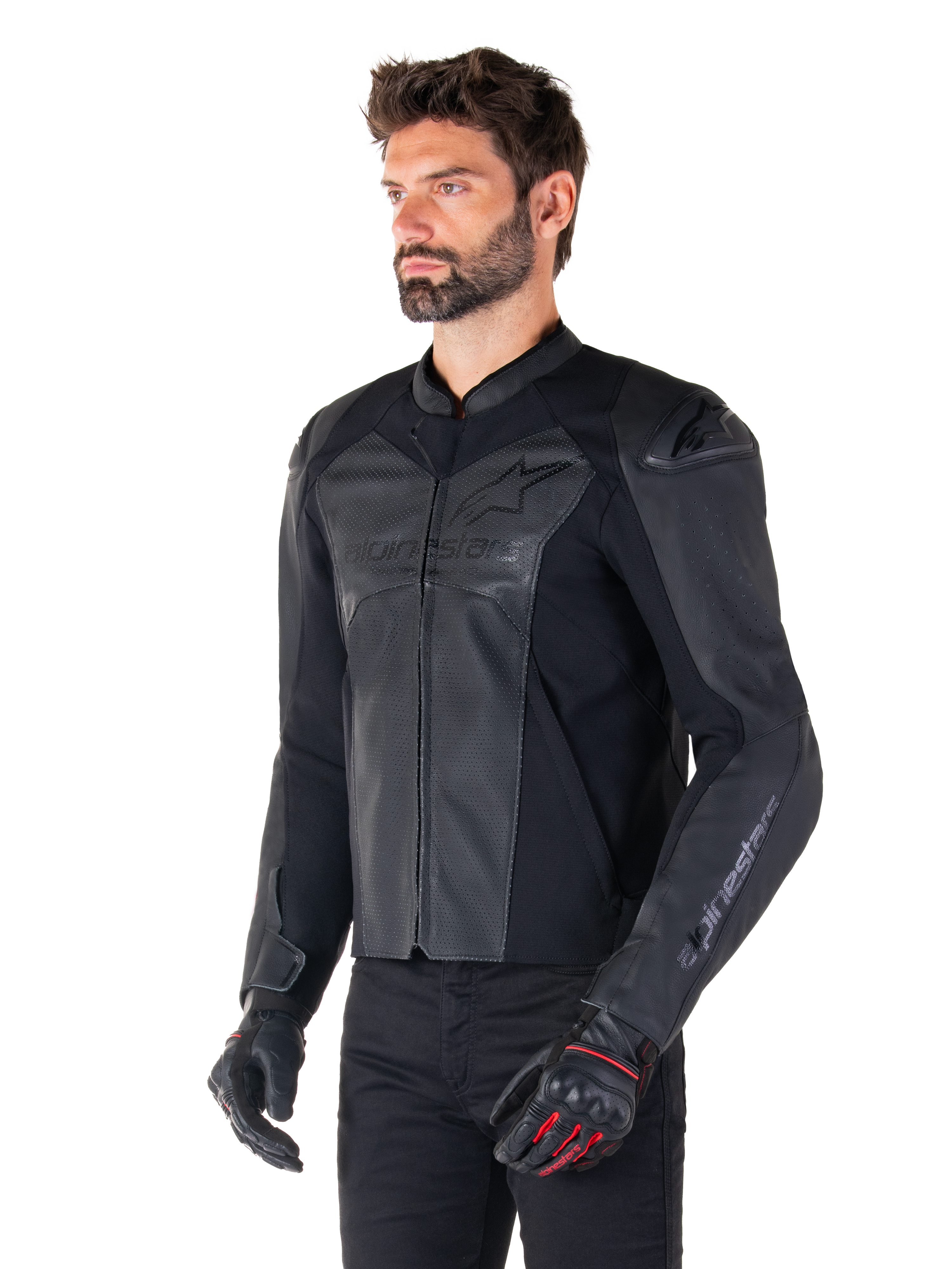 Model draagt de Alpinestars Faster V3 Airflow Leren Jas in Black Black, sportief motorjack met geperforeerd leer en stretchpanelen, gecombineerd met een zwarte broek en zwarte handschoenen met rode accenten, strakke op de racerij geïnspireerde stijl.