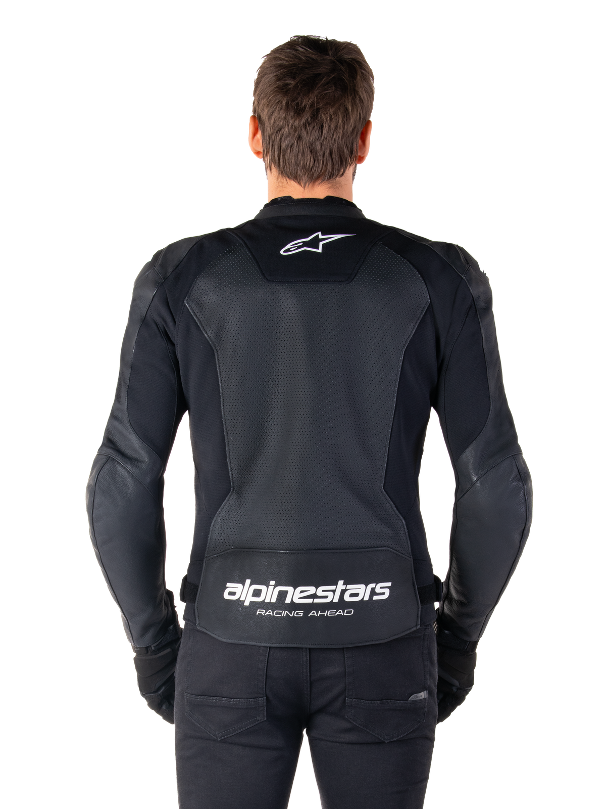 Alpinestars Faster V3 Airflow Leren Jas, zwart en wit, achteraanzicht van een rijder met het geperforeerde leren rugpaneel voor ventilatie, wit Alpinestars-logo op de bovenrug en 'RACING AHEAD' branding op de onderrug, sportieve motoruitrusting