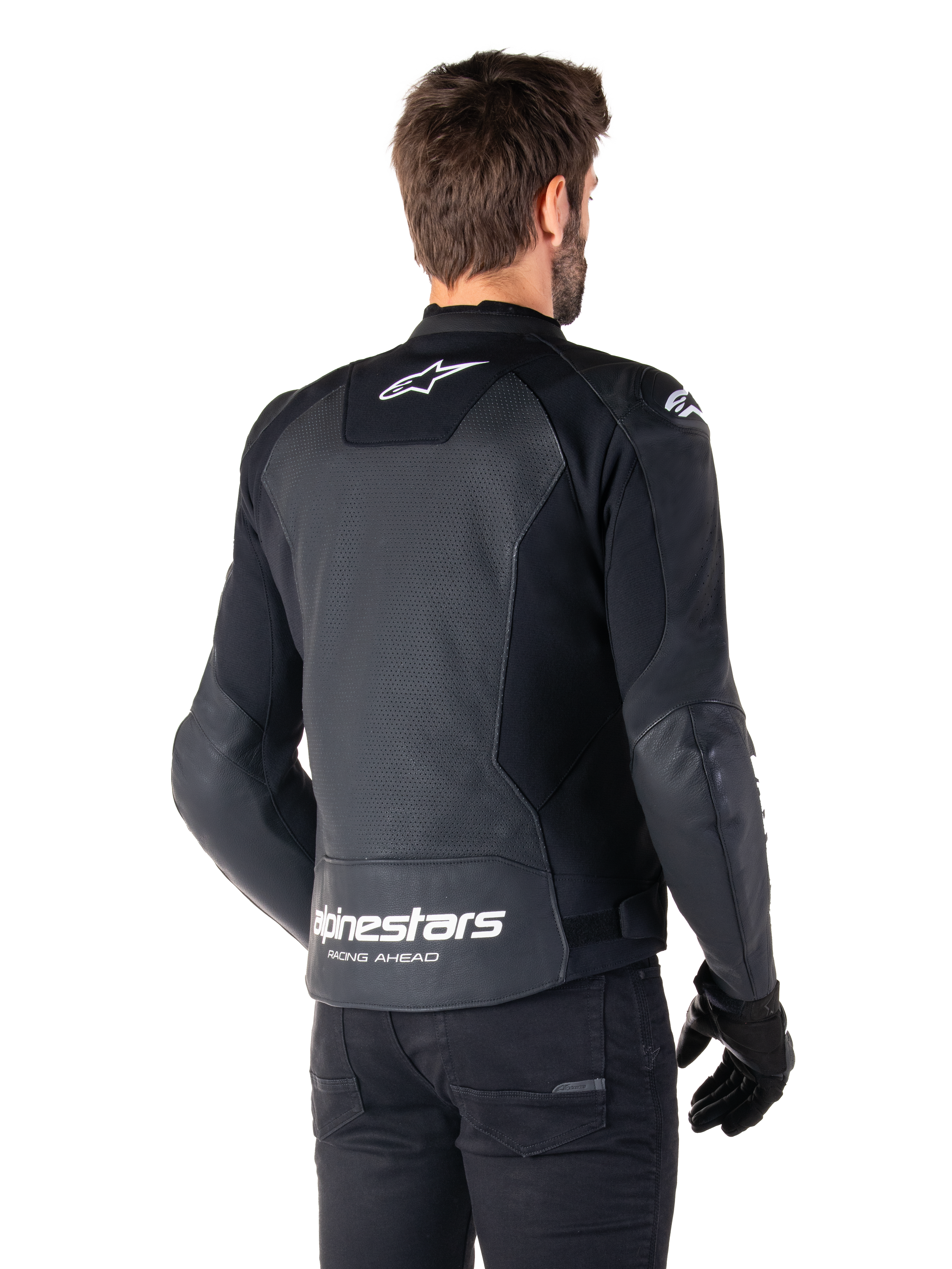Alpinestars Faster V3 Airflow Leren Jas, zwart en wit, achteraanzicht op een model, geperforeerd lederen rugpaneel voor ventilatie, witte Astars-logo's op de bovenrug en onderrug met 'Racing Ahead'-tekst, sportief ontwerp met stretchpanelen voor motorrijden.