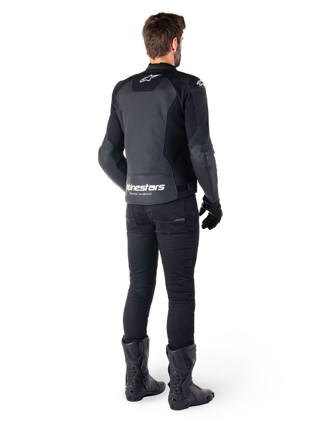 Alpinestars Faster V3 Airflow leren jas, zwart en wit, achteraanzicht met geperforeerde leren panelen en opvallende Alpinestars-branding op de onderrug, gedragen door een motorrijder met zwarte motorbroek, handschoenen en laarzen