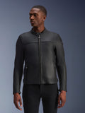 Alpinestars Blacktrack leren motorjas, zwart, gedragen door een model, voorzien van een metalen ritssluiting aan de voorzijde, hoge kraag en zakken met rits, strakke premium leren constructie voor een moderne minimalistische look