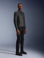 Mannelijk model draagt Alpinestars Blacktrack leren jas, Black on Black, moderne bikerstijl met premium leer en metalen ritsdetails, gecombineerd met een zwarte broek en laarzen voor een eigentijdse stedelijke look
