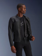 Alpinestars Blacktrack Leren Jas, zwart, premium rundleer met een op maat gemaakte pasvorm, opengeritst om het afneembare thermische vest en de interieurdetails te tonen, gedragen door een model, moderne urban motorkleding