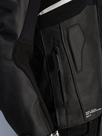 Alpinestars Atem V5 leren jas, zwart, close-up detail van de zijkant van de romp, voorzien van een zak met rits, geperforeerd leren paneel, wit reflecterend accent en 'One Goal. One Vision.' branding, hoogwaardige motorrace-kleding