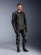 Alpinestars Caliber leren jas in het zwart, gecombineerd met bijpassende zwarte leren motorbroek, racehandschoenen en laarzen, mannelijk model in een complete sportieve weguitrusting