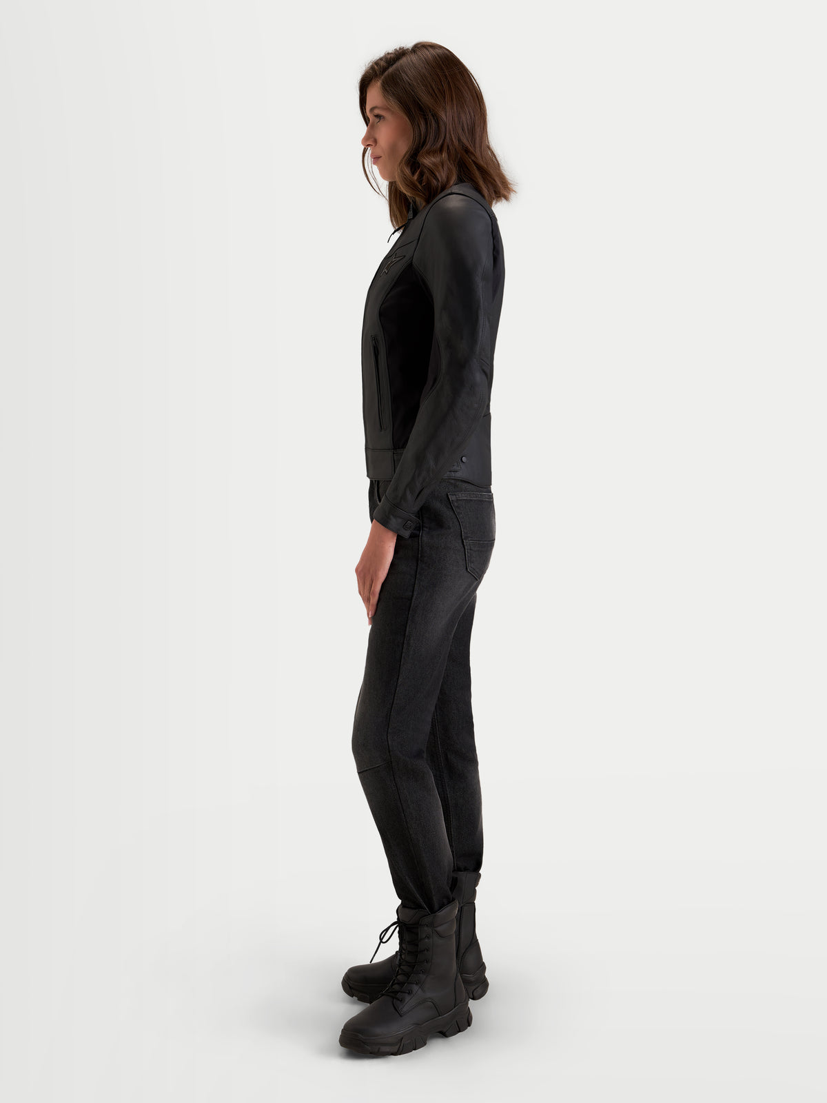 Alpinestars Stella Maver X leren jas, dames urban contemporary motorjas, zwart, zijaanzicht gedragen door een model die de getailleerde pasvorm en de premium lederen constructie toont