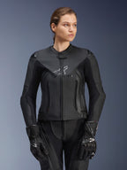 Alpinestars Stella GP Plus V4 leren jas, zwart, motorracejas voor dames, hoogwaardige leren constructie met beschermende vulling, strak ontwerp met subtiel logo, gedragen door een vrouwelijk model met bijpassende zwarte uitrusting