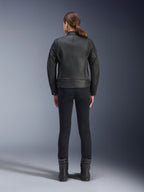 Alpinestars Stella Dyno leren jas, motorjas voor dames, zwart, achteraanzicht met nadruk op de getailleerde runderleren constructie, minimalistisch erfgoedontwerp, gedragen met een zwarte motorbroek en laarzen voor een urban motorlook