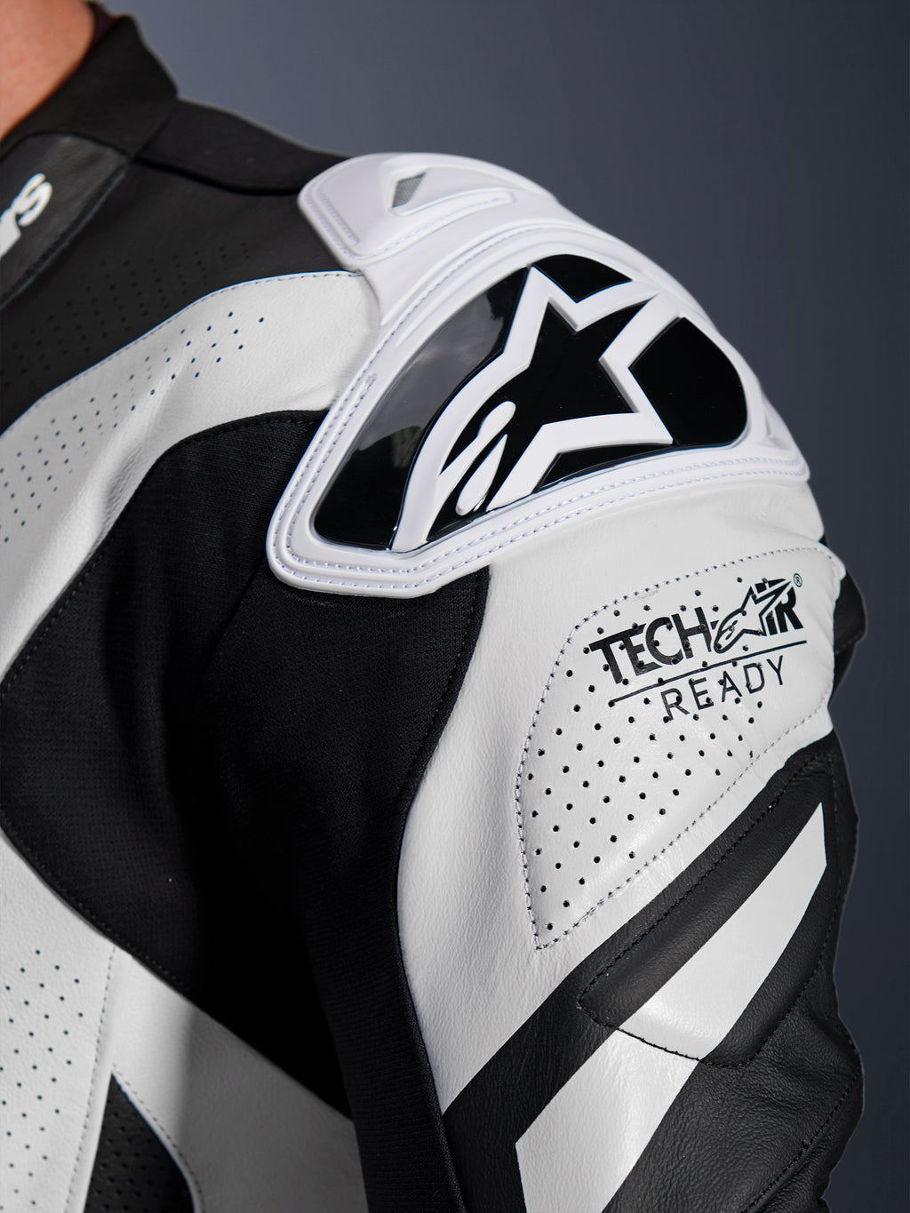 Alpinestars GP Plus V4 Sprint leren pak schouderbescherming, zwart en wit geperforeerd leer met Tech-Air Ready-logo.