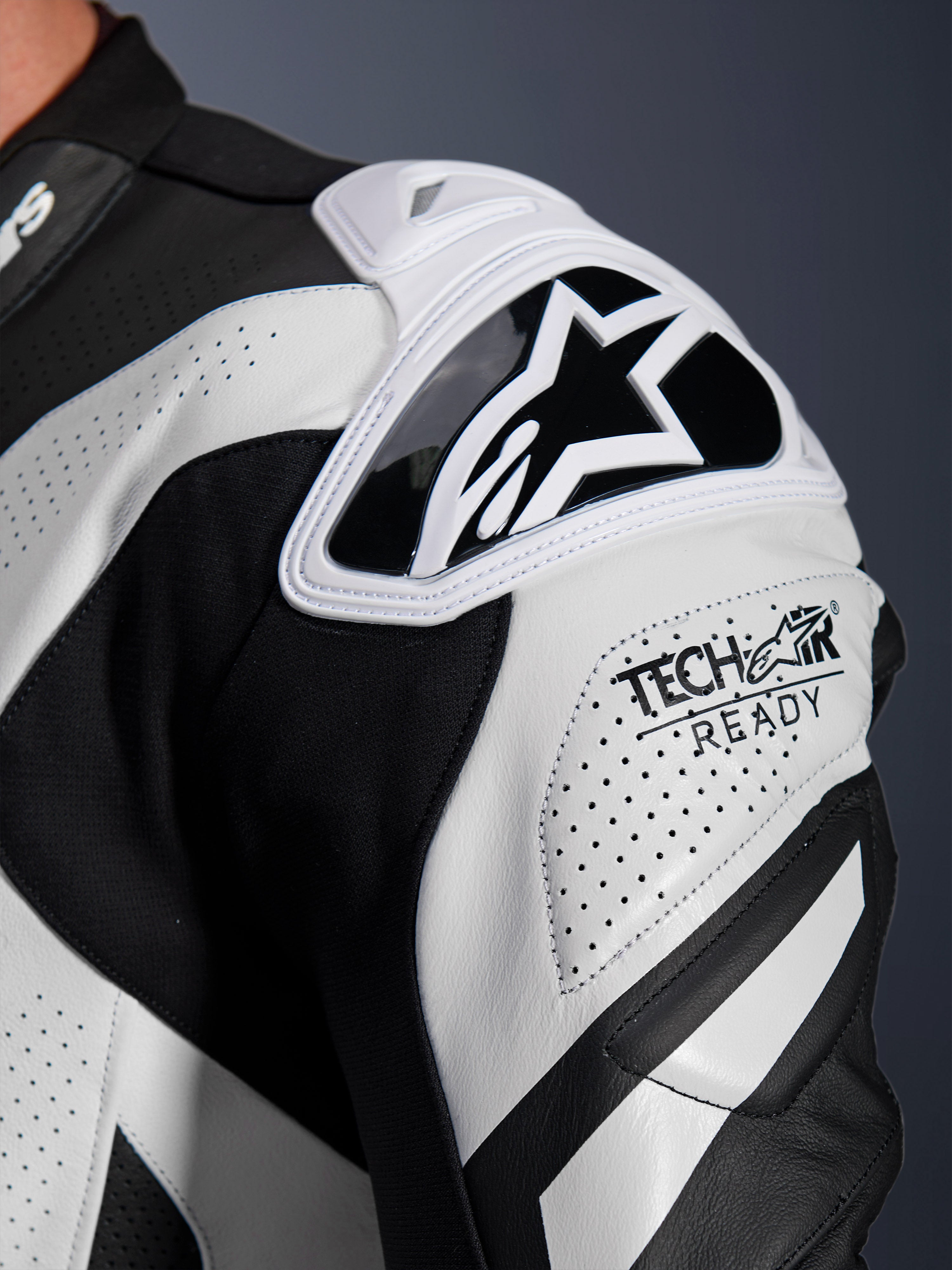 Alpinestars GP Plus V4 Sprint leren pak schouderbescherming, zwart en wit geperforeerd leer met Tech-Air Ready-logo.