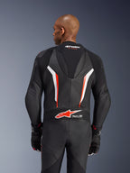 Alpinestars GP Force V2 leren pak, 1-delig motorpak, zwart, wit en fluo rood, achteraanzicht van het bovenlichaam met geperforeerd leer en Tech-Air Ready-logo, gedragen met bijpassende zwart-rode handschoenen
