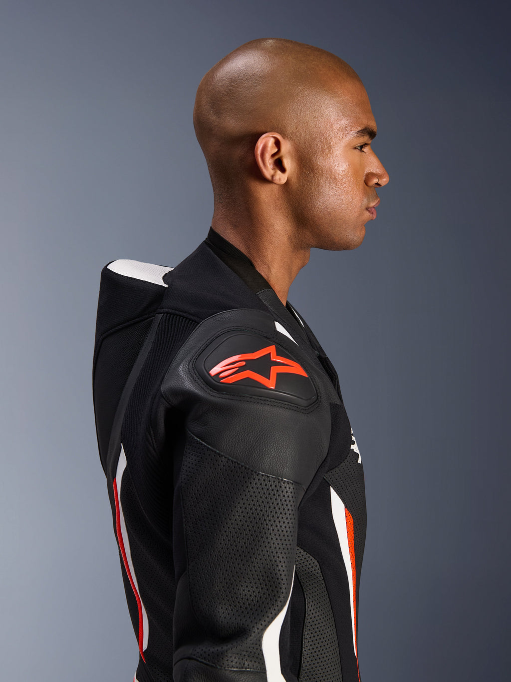 Alpinestars GP Force V2 Lederen Pak - 1-delig, zijprofiel van een rijder, Black White Red Fluo kleurstelling, met de nadruk op de aerodynamische speedhump, geperforeerde lederen zones en DFS Lite schouderbescherming met rood Alpinestars-logo