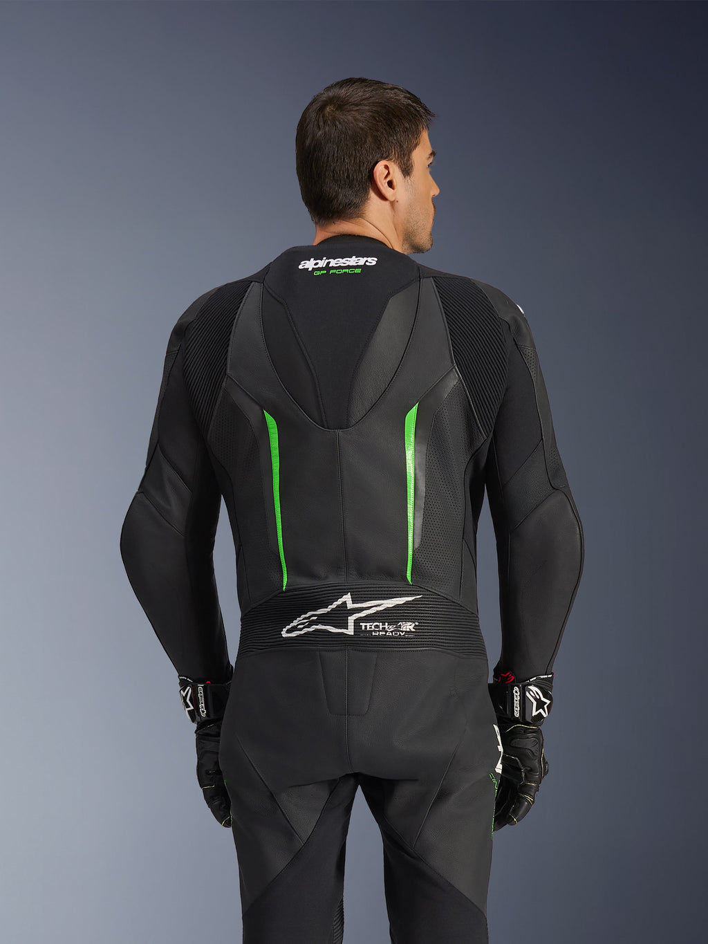 Alpinestars GP Force V2 Leren Pak - 1-delig, zwart en groen, achteraanzicht met aerodynamische speed hump, Tech-Air Ready-branding, geperforeerde lederen zones en accordeon stretchpanelen voor motorracen