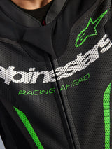 Alpinestars GP Force V2 Leren Pak - 1-delig, close-up van het borstgedeelte, zwart geperforeerd leer met witte Alpinestars-branding, groene 'RACING AHEAD' tekst en groene accenten