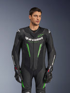 Alpinestars GP Force V2 Leren Pak - 1-delig, zwart en groen motorracepak, gedragen door een model, met geperforeerde leren panelen, opvallende witte Alpinestars-branding op de borst en mouwen en geïntegreerde schouderbescherming voor circuitprestaties.