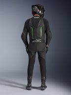 Rijder van achteren in het Alpinestars GP Force V2 Leren Pak - 1-delig in zwart en groen, gecombineerd met een zwarte carbon helm, zwarte racehandschoenen en zwarte laarzen, voorzien van een aerodynamische speed hump en Tech-Air Ready branding.