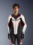 Alpinestars GP Force V2 Leren Pak - 1-delig, Wit Zwart en Rood Fluo, gedragen door een mannelijk model, voorzien van geperforeerde leren panelen en opvallende Alpinestars-branding op de borst, gecombineerd met zwart-witte racehandschoenen, ontworpen voor circuit- en prestatiegerichte ritten