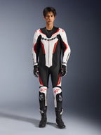 Alpinestars GP Force V2 Leren Pak - 1-delig, Wit Zwart Rood Fluo, eendelig leren motorracepak, vooraanzicht op model, voorzien van geperforeerde panelen en rode accenten, opvallende Alpinestars-branding op de borst, gestyled met professionele racelaarzen en handschoenen