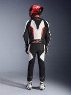 Alpinestars GP Force V2 Leren Pak - 1-delig, Wit Zwart Rood Fluo, achteraanzicht met de nadruk op de aerodynamische speed hump en Tech-Air Ready branding, gedragen met rode racehelm en witte en zwarte laarzen, circuitgericht leren pak voor sportief rijden.