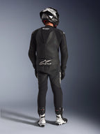 Alpinestars GP Force V2 2-delig leren pak in het zwart, volledig achteraanzicht met aerodynamische speedhump en Tech-Air Ready-branding, gecombineerd met bijpassende zwart-witte helm en witte racelaarzen voor professionele circuitprestaties