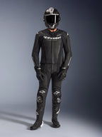 Alpinestars GP Force V2 2-delig leren pak, zwart, volledige motorrace-uitrusting inclusief zwarte helm, handschoenen en laarzen, voorzien van geperforeerde leren panelen en witte Alpinestars-logo's op de borst en knieën, ontworpen voor hoogwaardige circuitritten.