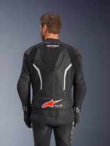 Alpinestars GP Force V2 tweedelig leren pak, zwart, wit en rood fluo, achteraanzicht van het leren jack, voorzien van het Tech-Air Ready logo, witte accenten, geperforeerde lederen panelen en accordeonstretch voor bewegingsvrijheid.