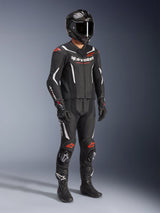 Alpinestars GP Force V2 tweedelig leren pak, zwart wit en rood fluo, volledige motorrace-uitrusting met carbonfiber helm, racehandschoenen en laarzen, leren constructie met geperforeerde panelen en aerodynamische speed hump.