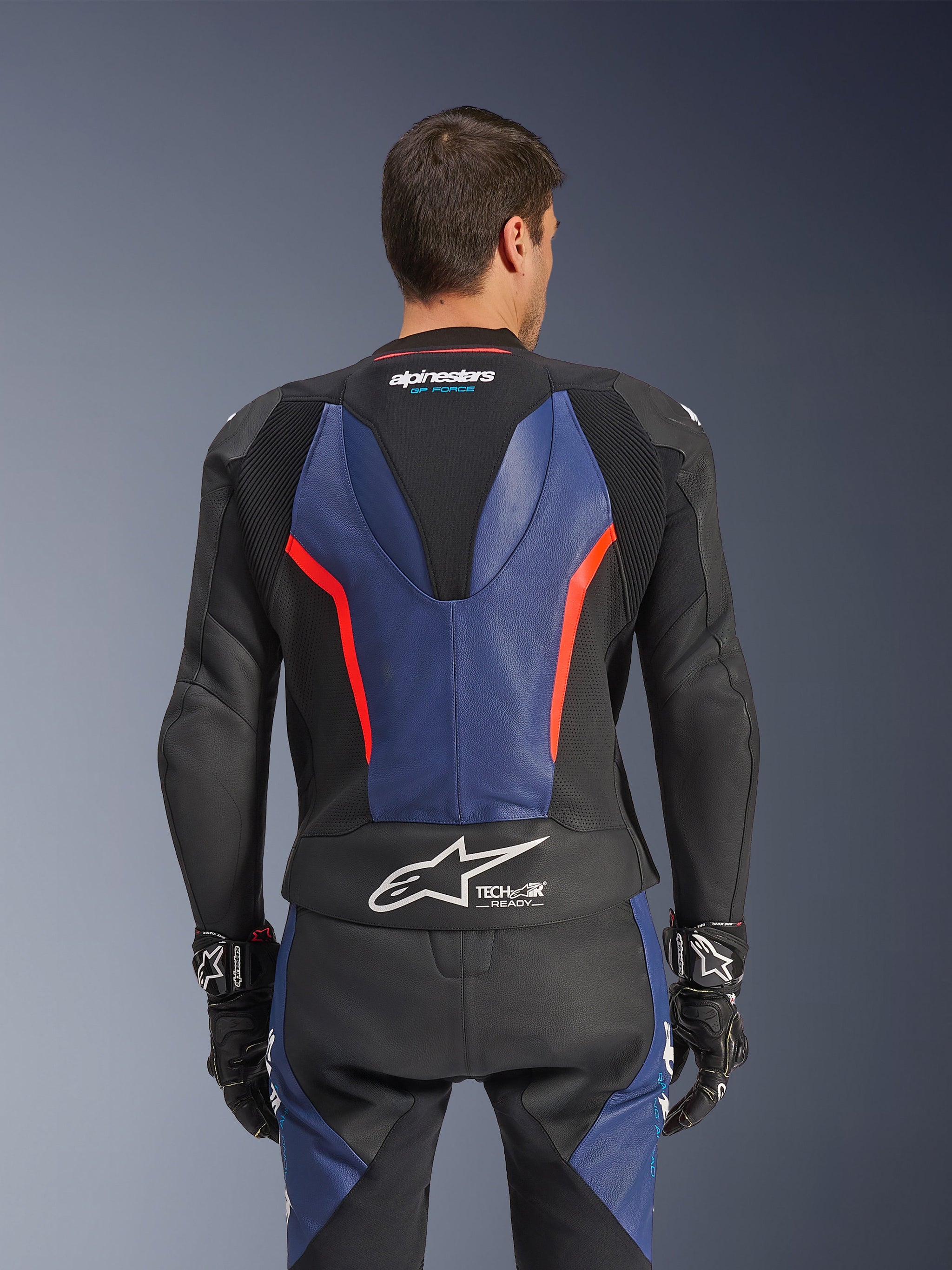 Alpinestars GP Force V2 Leather Suit 2-Piece, achteraanzicht, zwart met blauwe en rood fluo accenten, geperforeerde lederen constructie, Tech-Air Ready-branding op de taille, ergonomische stretchpanelen voor raceprestaties