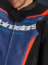 Alpinestars GP Force V2 Leren Pak, 2-delig, detailopname van de borst, geperforeerd blauw leer met wit logo en 'RACING AHEAD' tekst, fluo rode accenten en zwarte panelen, professionele sportuitrusting voor motorrijders