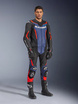 Alpinestars GP Force V2 Leather Suit 2-Piece, 2-delig lederen motorpak, zwart, blauw en fluo rood, gedragen met bijpassende zwarte racehandschoenen en laarzen, voorzien van geperforeerde panelen en beschermende sliders, aerodynamisch ontwerp voor sportief rijden