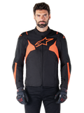 Alpinestars T-Jaws V4 waterdichte jas, sportieve motorjas, zwart met Red Fluo, voorzien van neon accenten en een opvallend sterlogo op de borst, gedragen door een mannelijk model met zwarte motorhandschoenen, strak race-geïnspireerd textielontwerp