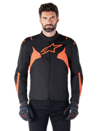 Alpinestars T-Jaws V4 waterdichte jas, sportieve motorjas, zwart met Red Fluo, voorzien van neon accenten en een opvallend sterlogo op de borst, gedragen door een mannelijk model met zwarte motorhandschoenen, strak race-geïnspireerd textielontwerp