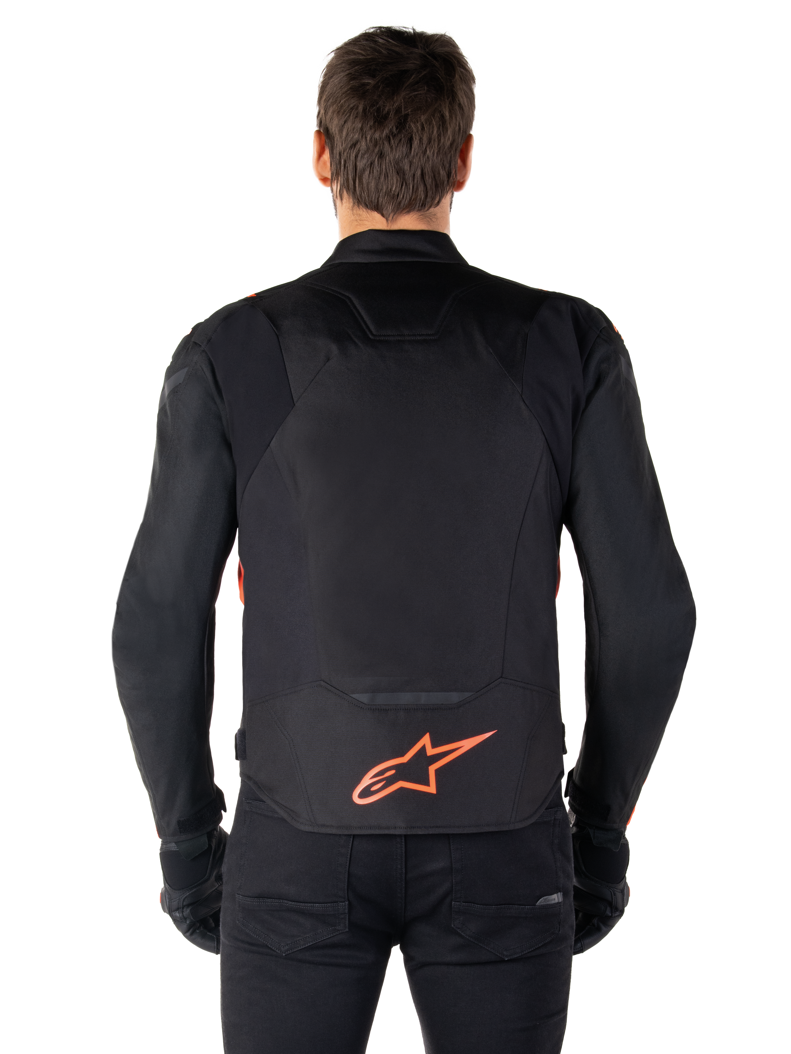 Alpinestars T-Jaws V4 Waterproof Jacket, achteraanzicht, zwart met fluo rood, voorzien van een rood Alpinestars-logo op de onderrug, technische textielconstructie, gedragen met een zwarte broek en handschoenen voor een complete sportieve rijlook