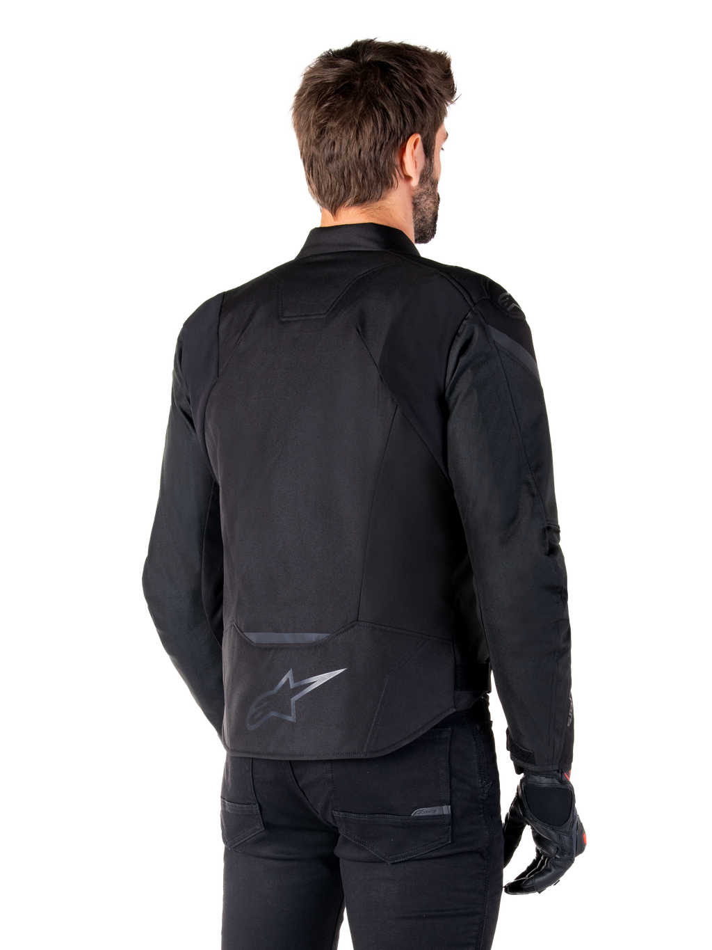 Alpinestars T-Jaws V4 Waterproof Jacket, zwart, achteraanzicht op model, met een reflecterend Alpinestars-logo op de onderrug, verlengde achterkant voor extra dekking, sportief textielontwerp met tonale panelen, gedragen met zwarte motorhandschoenen