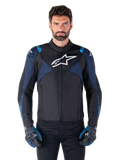 Alpinestars T-Jaws V4 Waterproof Jacket, motorjas, zwart en donkerblauw met Blithe Blue accenten, wit logo op de borst, blauwe tekst op de schouders, gedragen met bijpassende handschoenen, waterdichte textiele motorkleding
