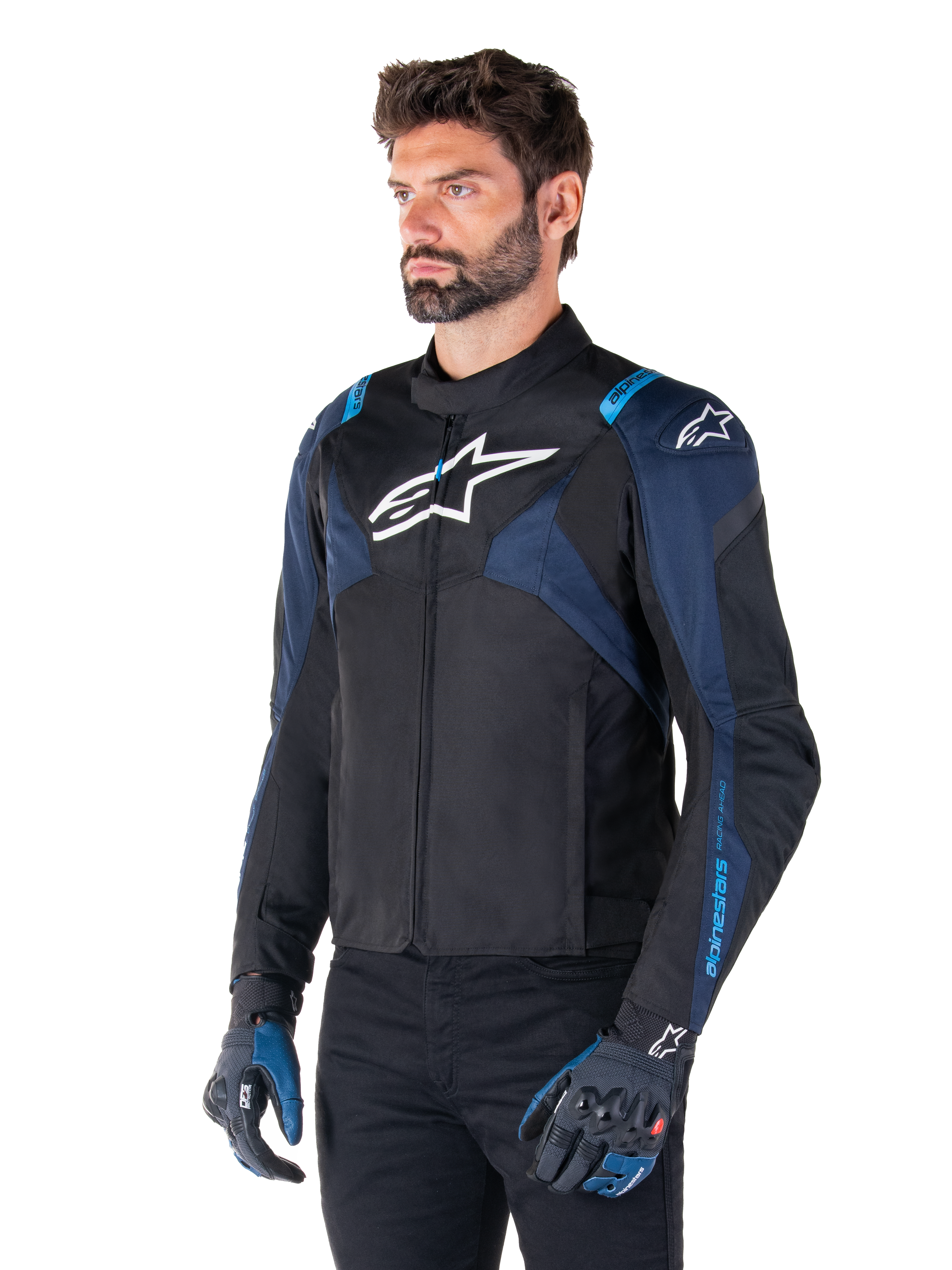 Alpinestars T-Jaws V4 Waterproof Jacket, motorjas, zwart met donkerblauw en Blithe Blue, gedragen door een model met bijpassende handschoenen en een zwarte broek, witte Alpinestars-logo's op de borst en schouders met blauwe accenten op de mouwen, sportieve textiele motorkleding