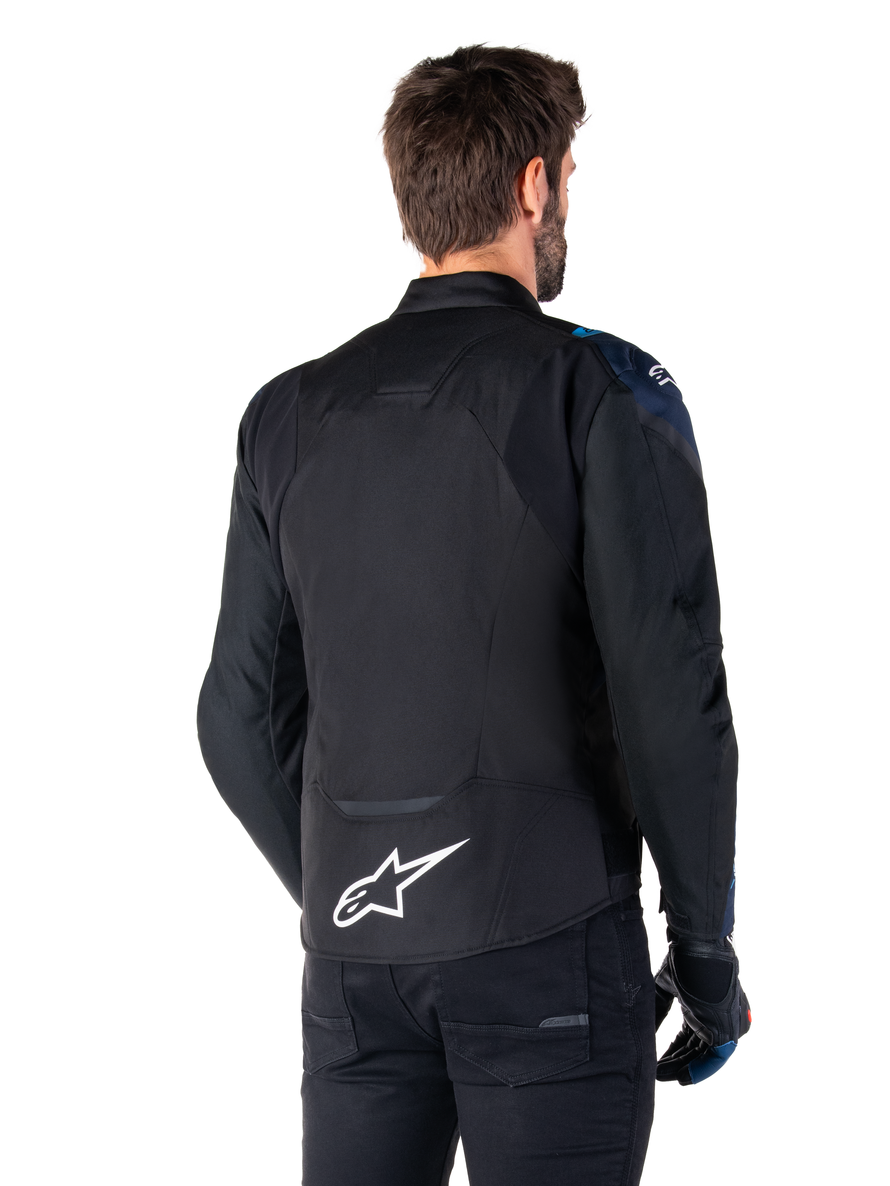 Alpinestars T-Jaws V4 Waterproof Jas, achteraanzicht, zwart met donkerblauwe en Blithe Blue accenten, wit sterlogo op de onderrug, sportief silhouet, gedragen met zwarte broek en motorhandschoenen