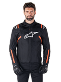 Alpinestars T-SPS V2 Waterproof jas, Black White en Red Fluo, gedragen door een mannelijk model met zwarte motorhandschoenen, voorzien van een groot wit Alpinestars-logo op de borst en levendige oranje accenten op de schouders en mouwen.