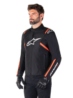 Alpinestars T-SPS V2 Waterproof jas, zwart, wit en fluo rood, gedragen door een mannelijk model met zwarte handschoenen en broek, voorzien van een wit Alpinestars-logo op de borst en fluorescerende rode accenten op de schouders en mouwen, sportief textielontwerp