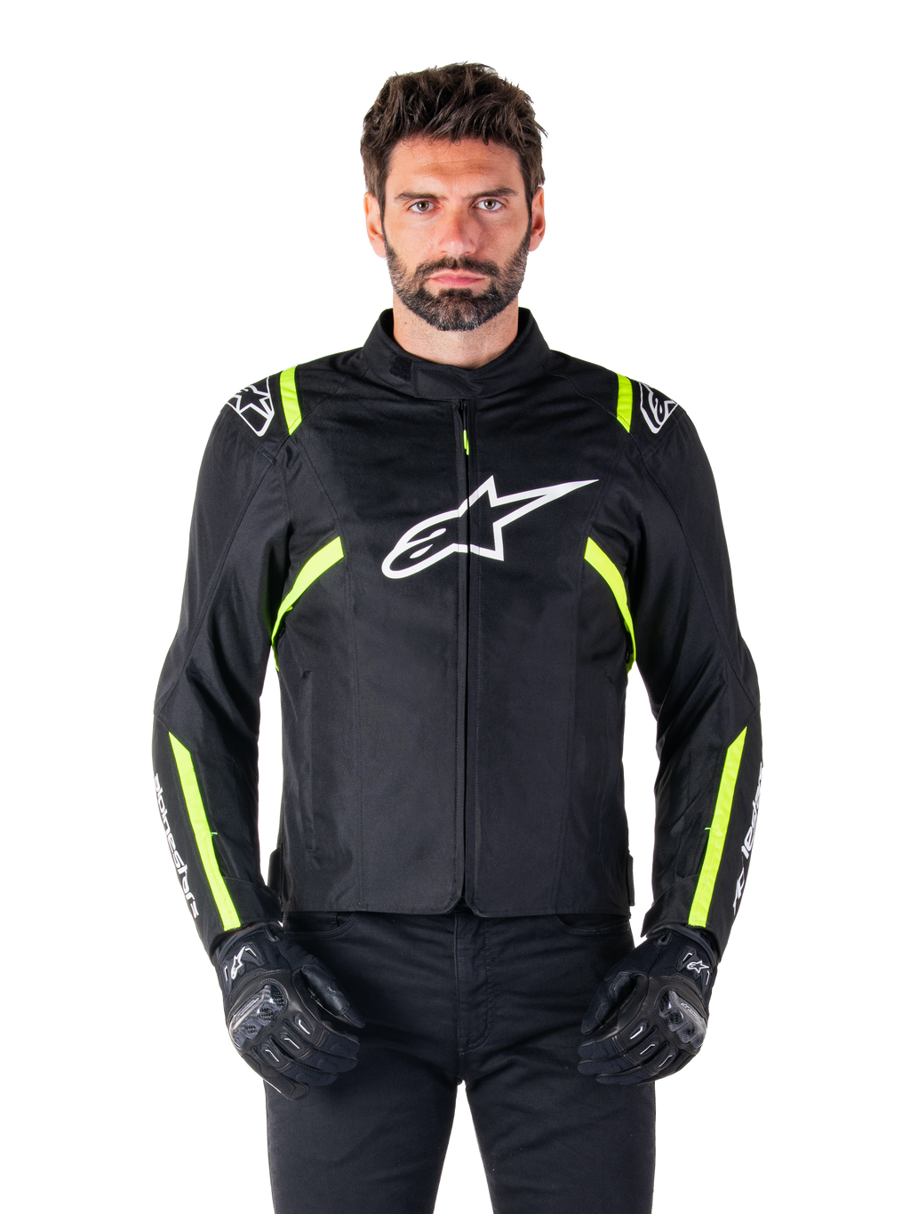 Alpinestars T-SPS V2 Waterproof Jacket, motorjas, zwart met witte en neongele accenten, gedragen door een model met zwarte handschoenen, met een wit sterlogo op de borst en neongele strepen op de mouwen en schouders, sportief gestileerde textieluitrusting voor rijden onder alle weersomstandigheden