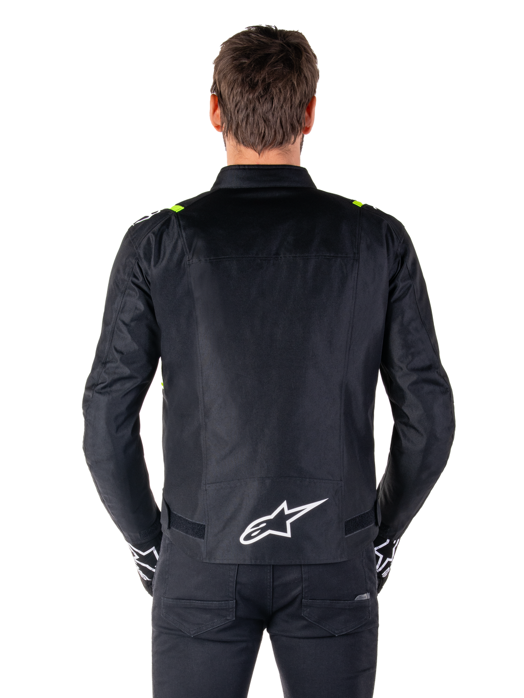 Alpinestars T-SPS V2 Waterproof Jas, achteraanzicht, zwart met fluogele accenten op de schouders en wit sterlogo op de onderrug, textiele motorjas met een sportief silhouet, gedragen door mannelijk model