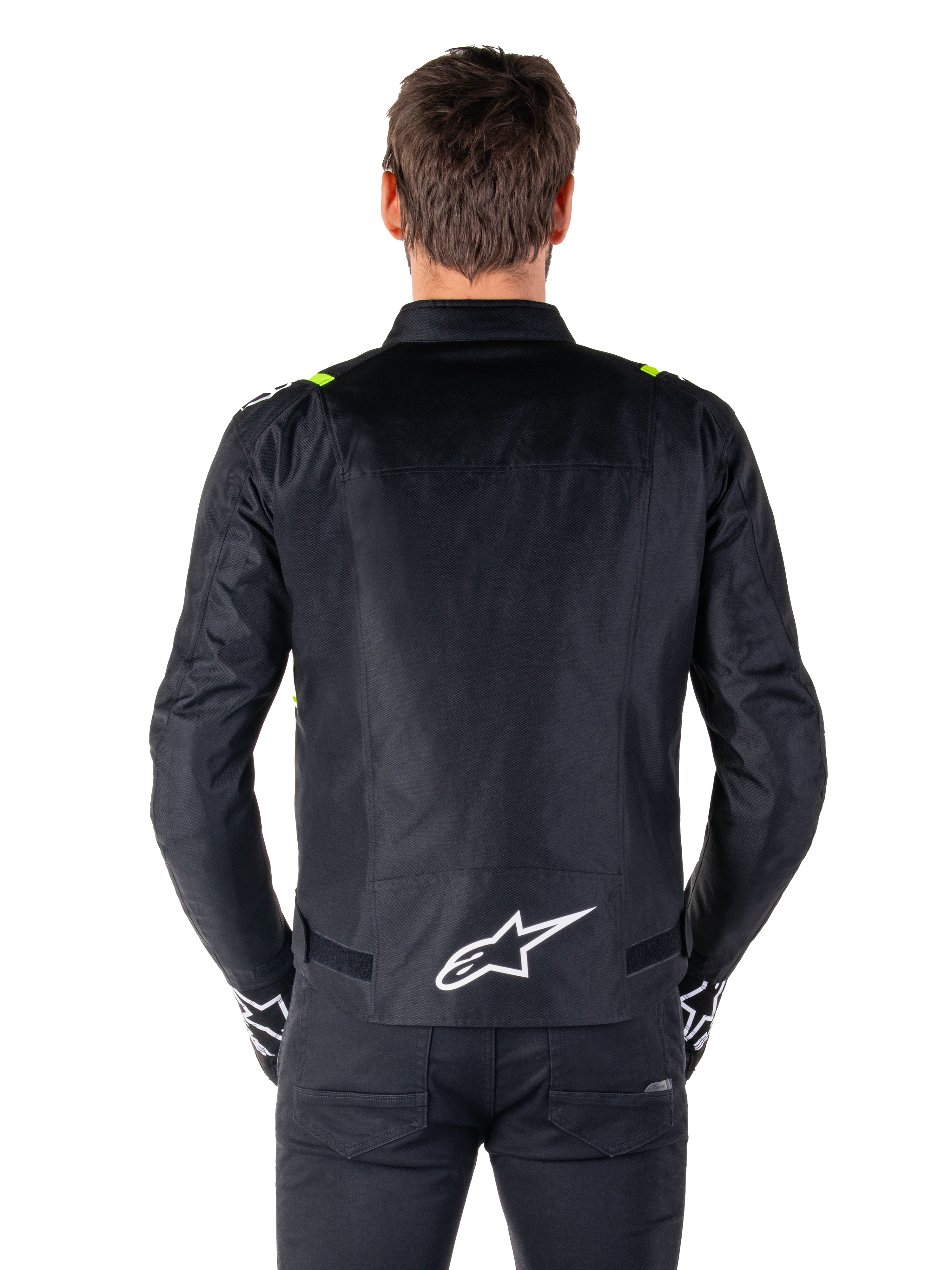 Alpinestars T-SPS V2 Waterproof Jas, achteraanzicht, zwart met fluogele accenten op de schouders en wit sterlogo op de onderrug, textiele motorjas met een sportief silhouet, gedragen door mannelijk model