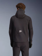 Alpinestars Aeroshell Waterproof Jacket, Black, rear view on model, featuring a hood and white 'ASTARS' logo on the lower back, worn with matching black pants and gloves, sleek softshell design for motorcycle riding